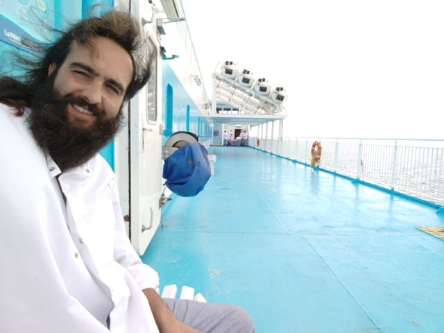 Bastien en tenue de cuisine, sur le pont du ferry
