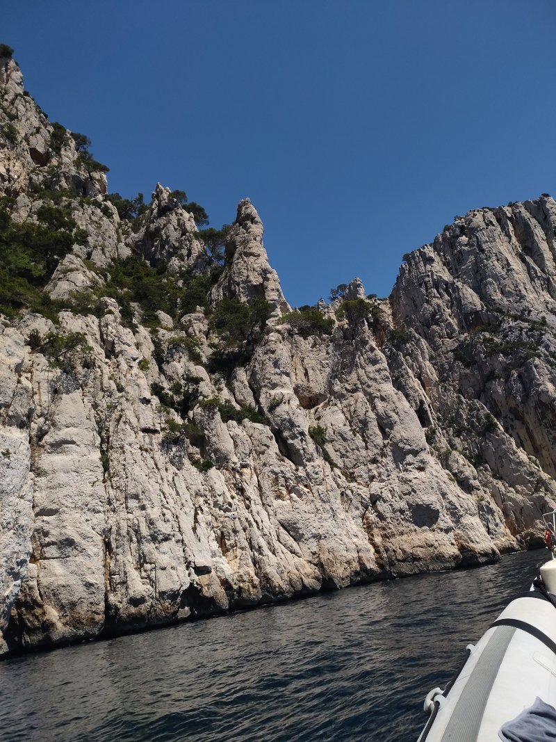 La vedette longe la falaise, au ras de l'eau
