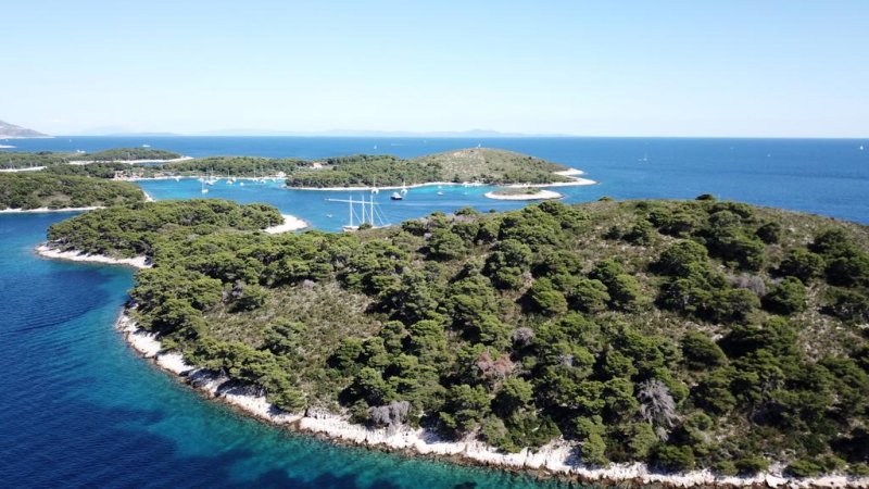 Îlots verts et eau turquoise aux abords de Korčula, avec des voiliers au mouillage
